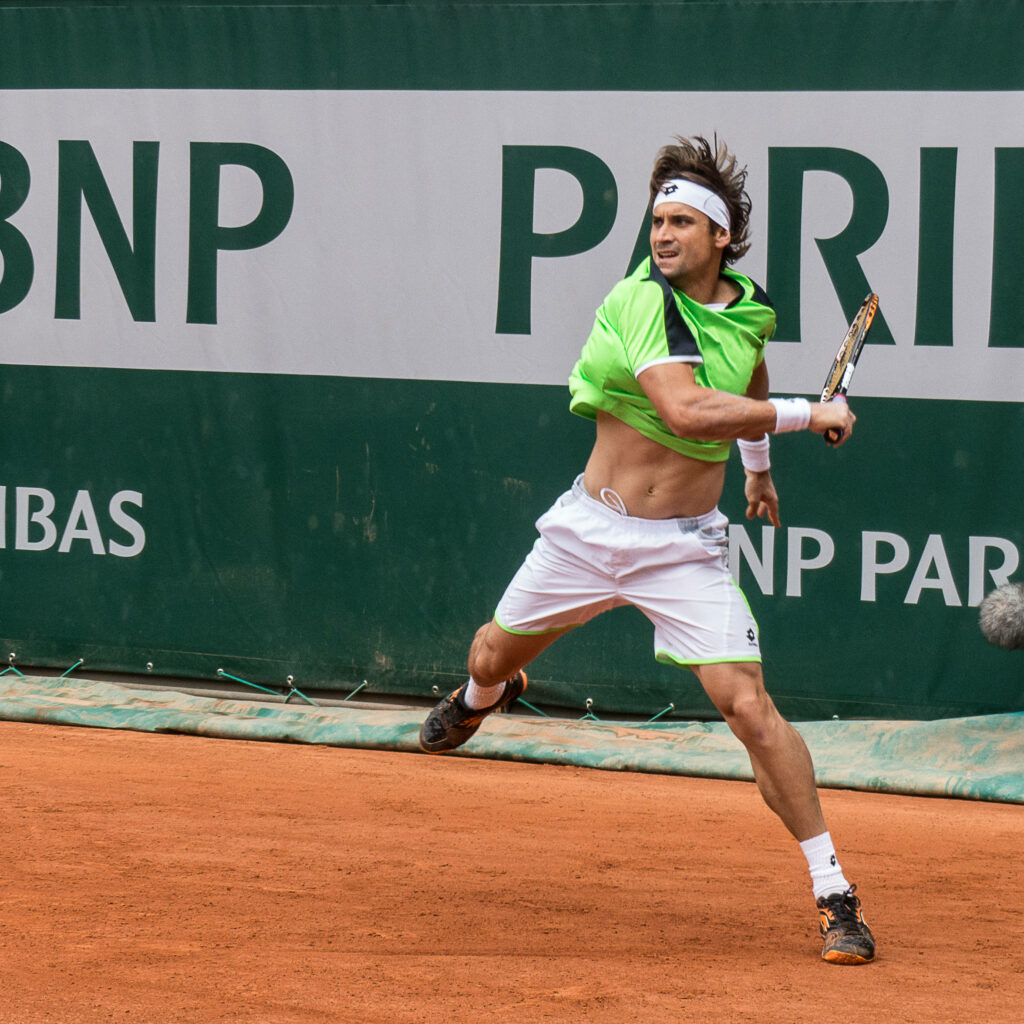 David Ferrer in bright green shirt returns shot on clay court BNP Paribas tennis tournament action Wallpaper