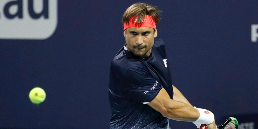 David Ferrer focused mid-game wearing red headband and navy sportswear with blurred tennis ball Wallpaper