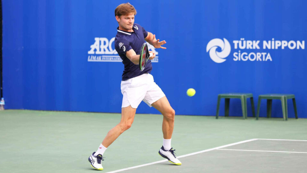 Tennis player David Goffin in action on court with intense focus and dynamic movement wallpaper background