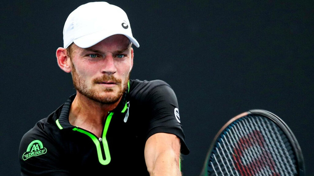 Close-up of David Goffin tennis player in black neon green gear intense focus action wallpaper