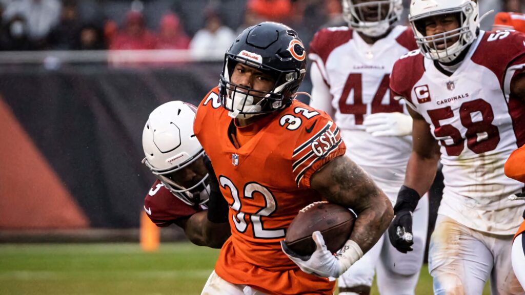 David Montgomery running with the Chicago Bears football in orange jersey during intense NFL game Wallpaper