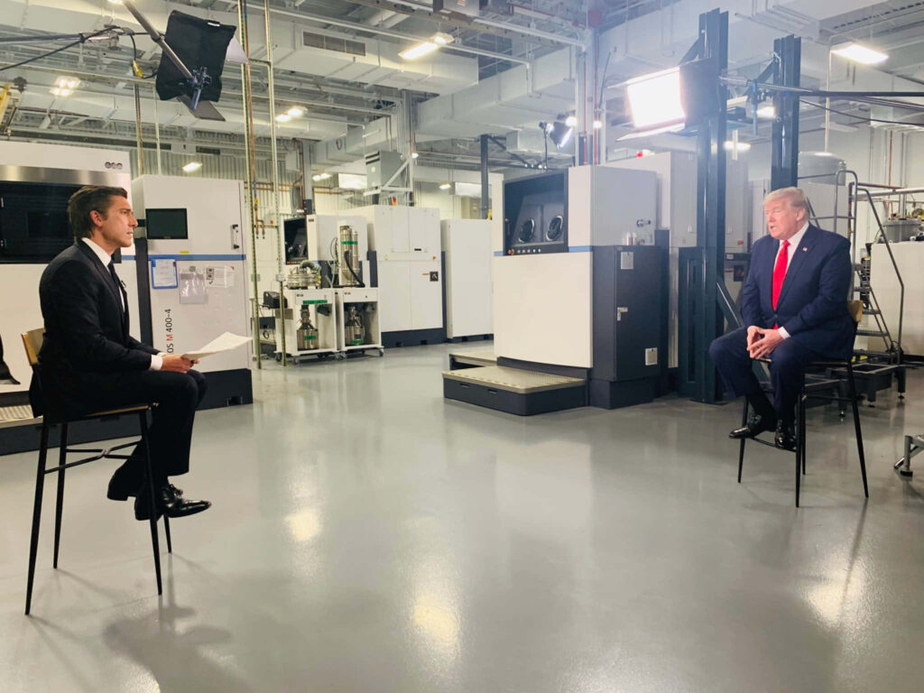 David Muir interviews Donald Trump in modern studio with industrial background and bright lights Wallpaper