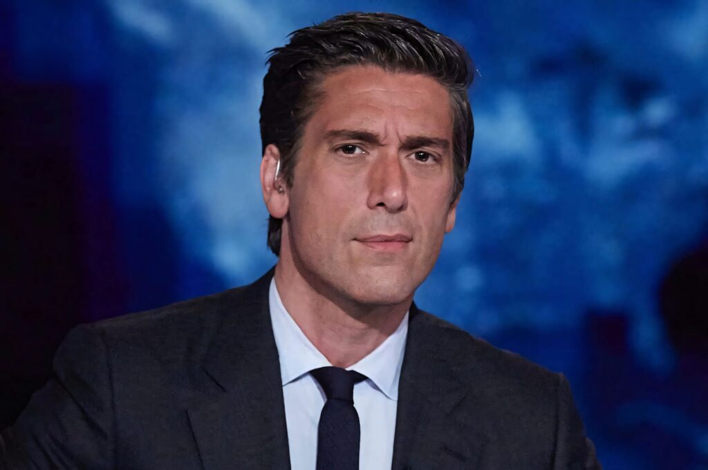 David Muir professional portrait in dark suit blue background serious expression studio lighting Wallpaper