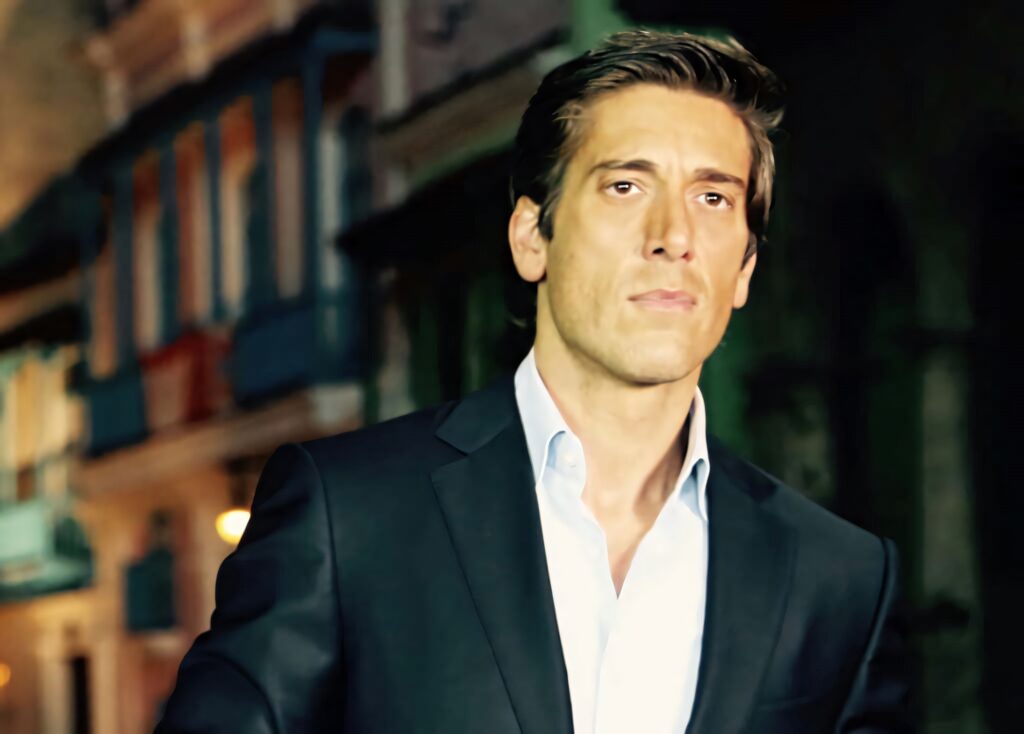 David Muir in dark suit stands confidently against blurred urban background professional style wallpaper