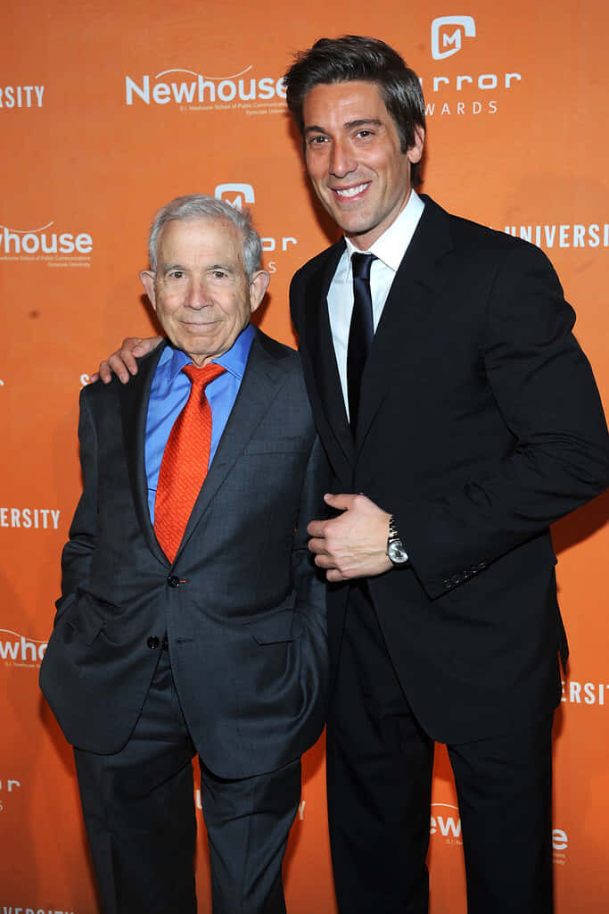 David Muir and Donald Newhouse in formal suits at Newhouse Mirror Awards orange backdrop event Wallpaper