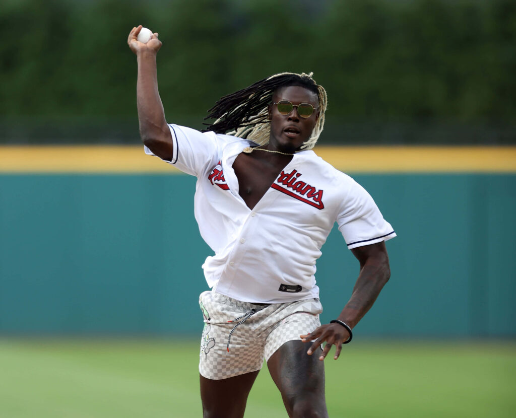 David Njoku in Cleveland Guardians jersey mid-throw first pitch vibrant stadium background Wallpaper
