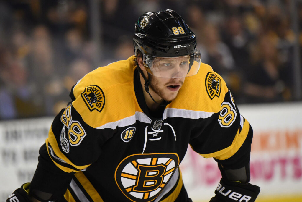 David Pastrnak Boston Bruins intense ice hockey action 2022 vibrant black and gold uniform Wallpaper