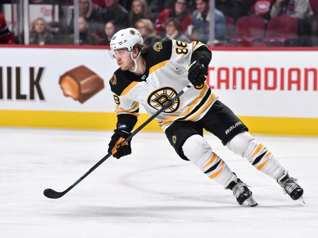 David Pastrnak Boston Bruins intense game action skating against Washington Capitals bright stadium Wallpaper