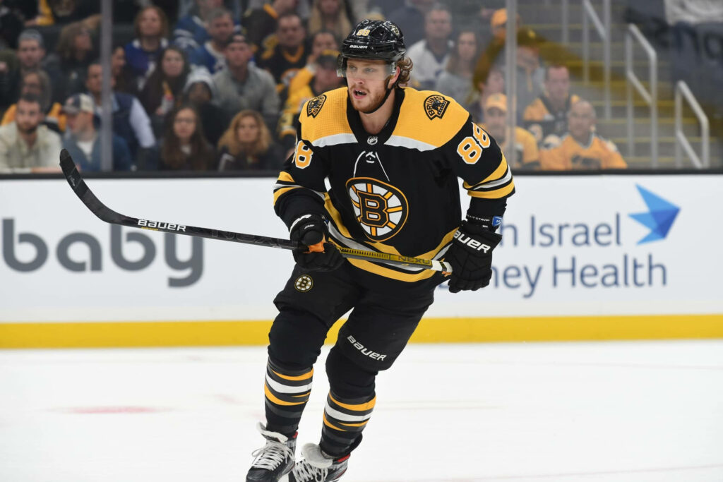 David Pastrnak #88 Boston Bruins skating intensely during a high-energy game versus New Jersey Devils Wallpaper