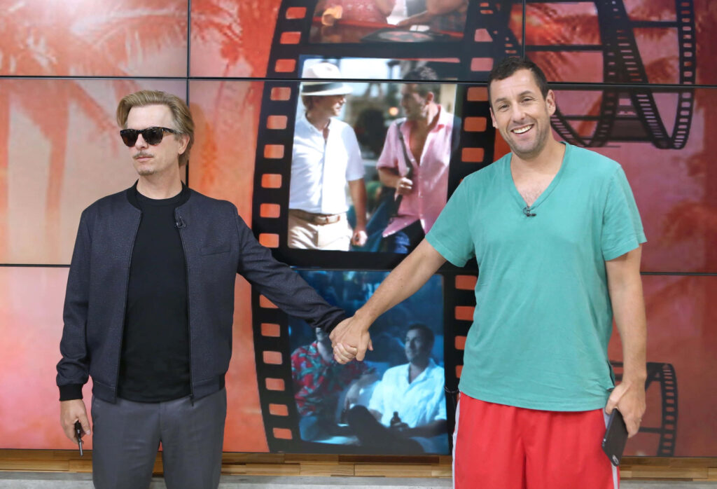 David Spade and Adam Sandler holding hands on Good Morning America set with tropical film strip background Wallpaper