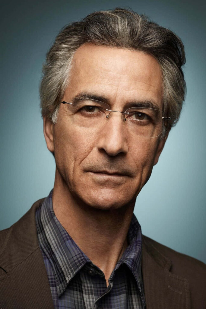 David Strathairn portrait wallpaper with grey hair glasses calm expression blue gradient background