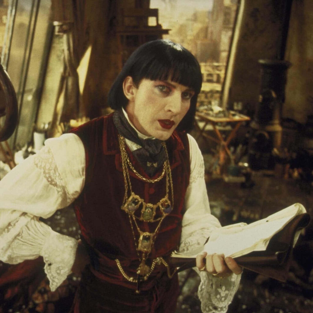 David Wenham in Victorian costume with lace sleeves and gold chains in gothic theatrical scene Wallpaper