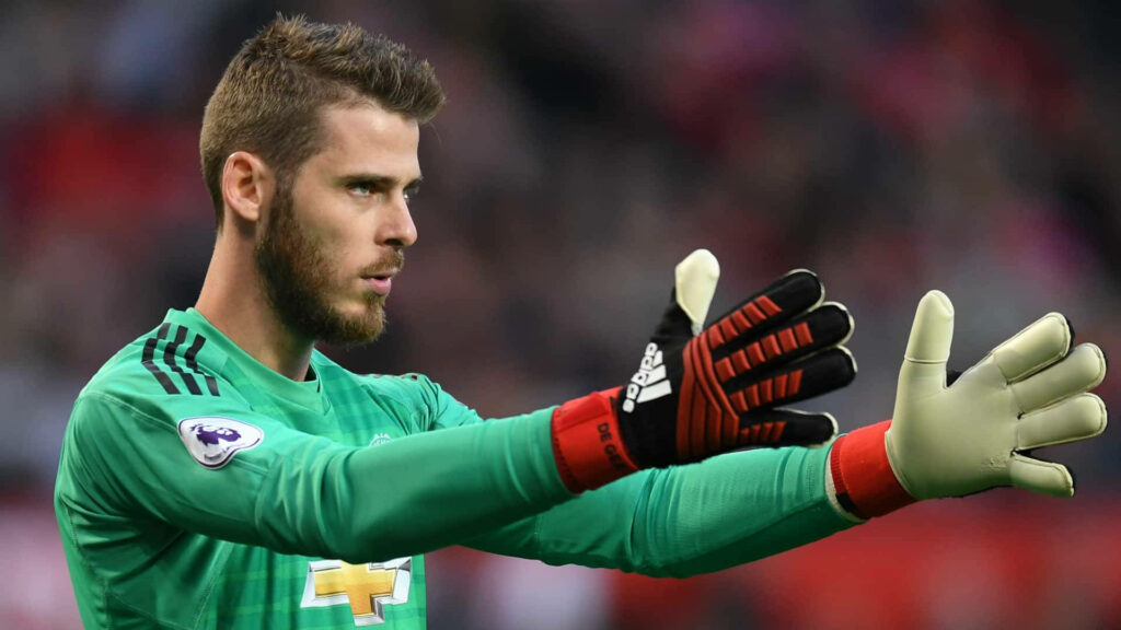 David de Gea in green goalkeeper kit focused with gloved hands ready during intense football match Wallpaper
