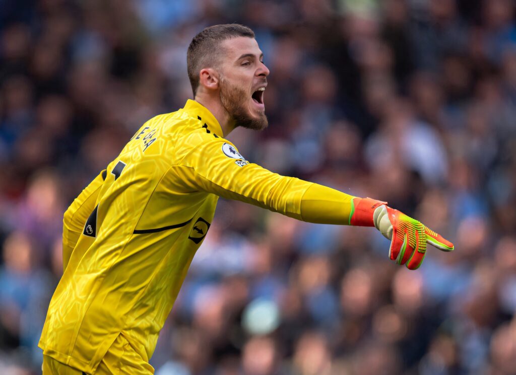 David de Gea shouting and pointing in bright yellow goalkeeper kit during intense stadium match Wallpaper