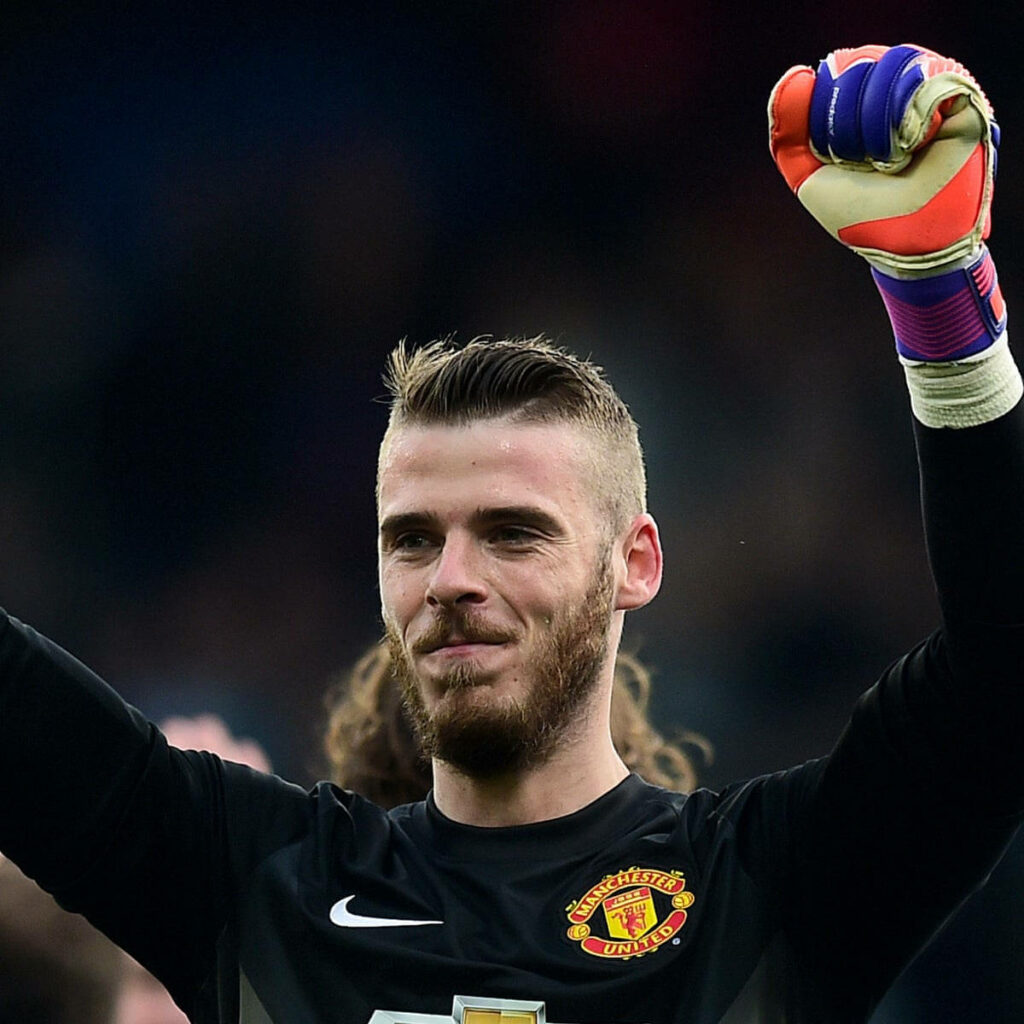 David de Gea celebrating in Manchester United goalkeeper kit with raised hands and bright gloves Wallpaper