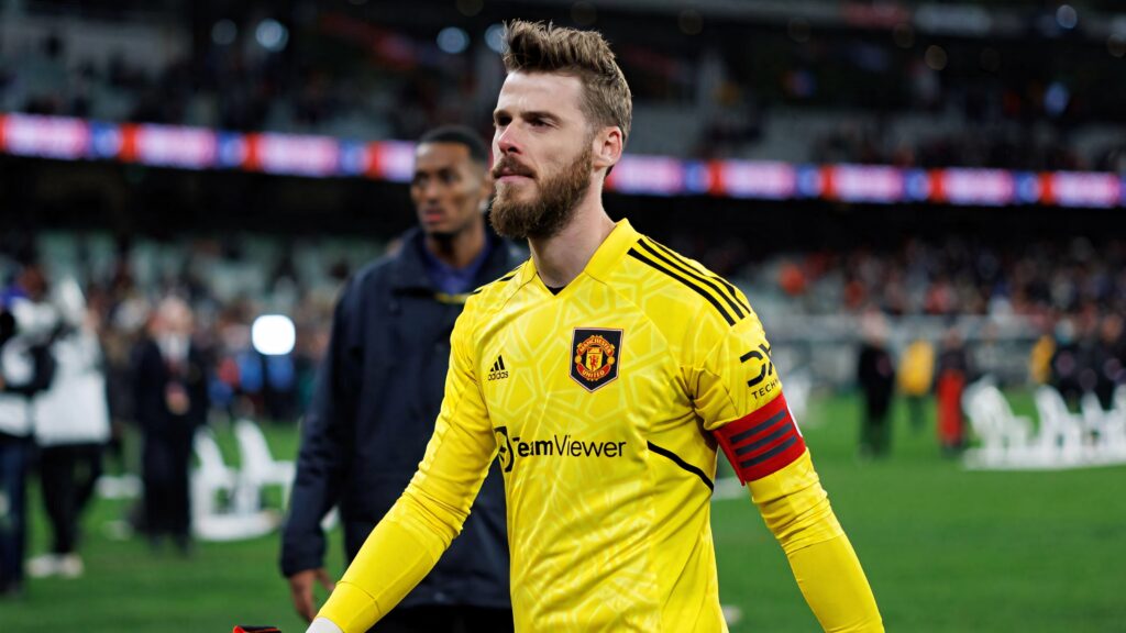 David de Gea in bright yellow Manchester United goalkeeper kit with red captain armband on pitch Wallpaper
