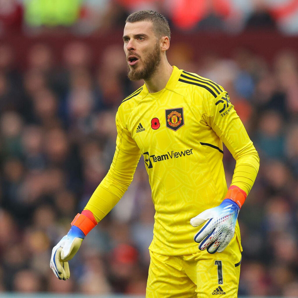 David de Gea in yellow goalkeeper kit with blue orange gloves ready in Premier League match Wallpaper