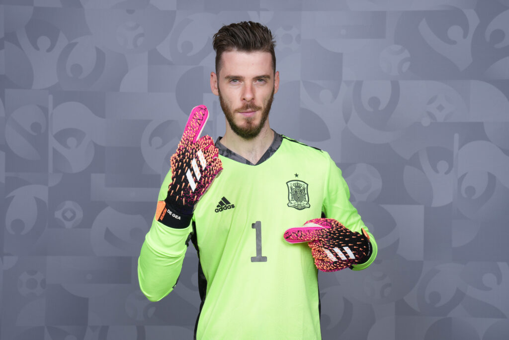 David de Gea in neon green Spain goalkeeper kit pointing up wearing patterned gloves gray football background Wallpaper