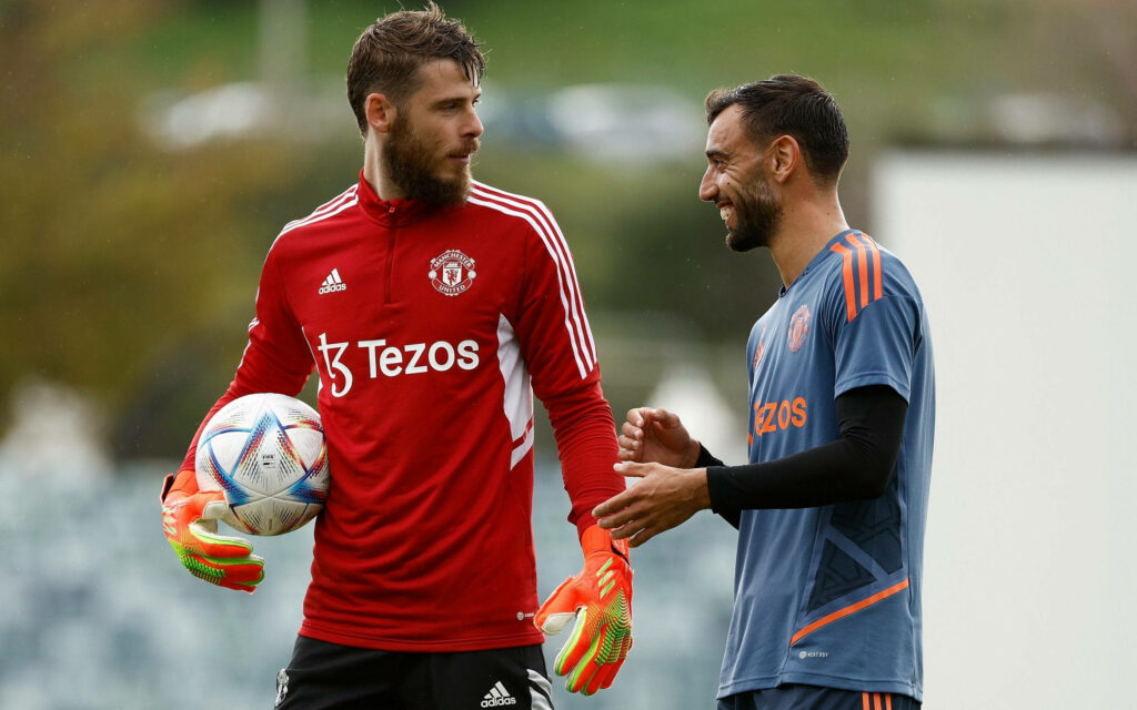 David de Gea and Bruno Fernandes in Manchester United training kits with Tezos logo holding bright soccer ball Wallpaper