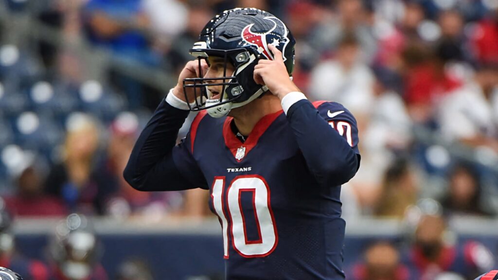 Davis Mills Houston Texans quarterback adjusting helmet on field vibrant stadium wallpaper background