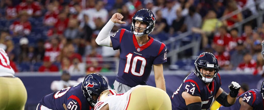 Quarterback Davis Mills signals at line of scrimmage in Houston Texans uniform game day action wallpaper