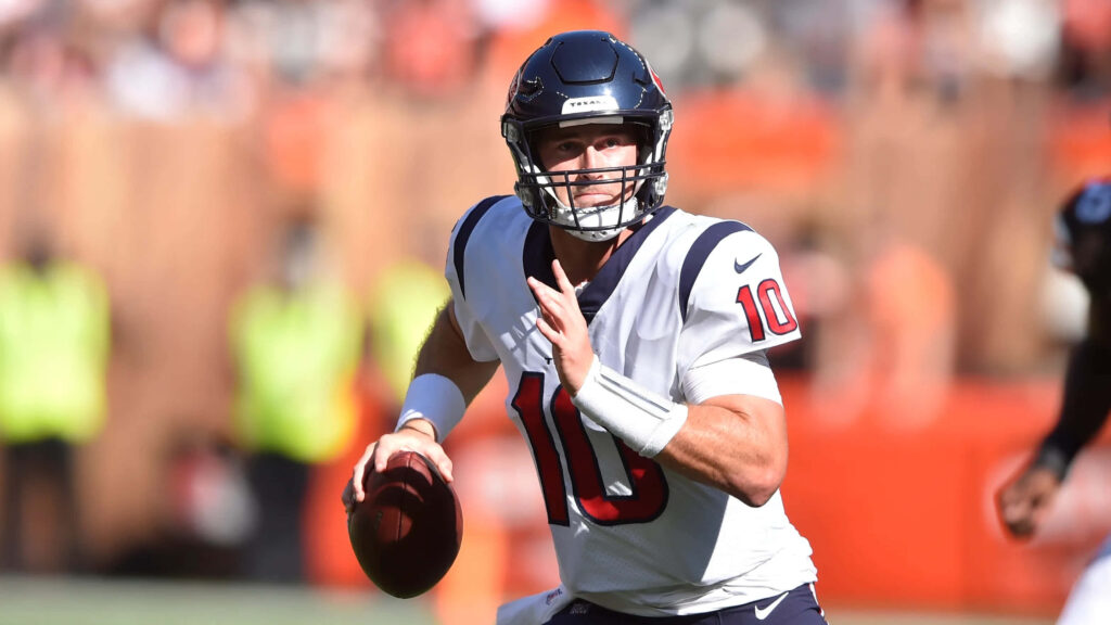 Davis Mills Houston Texans quarterback focused in action on football field with stadium background Wallpaper