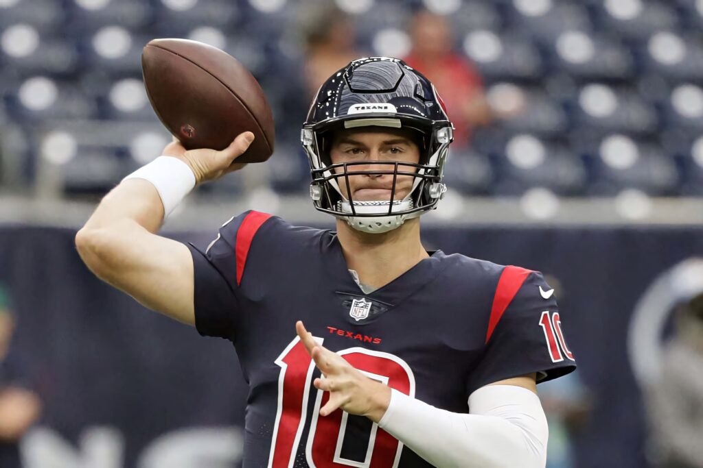 Davis Mills Houston Texans quarterback in dark uniform throwing football with focused intensity Wallpaper