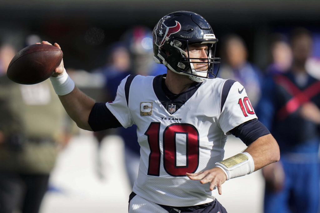Davis Mills Houston Texans quarterback poised to throw pass in white navy uniform game action Wallpaper