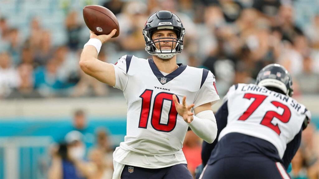 Davis Mills in Houston Texans uniform throws football with Christian SR in NFL game action Wallpaper