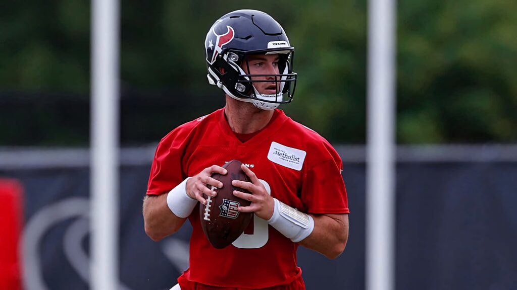 Davis Mills Houston Texans quarterback in red practice jersey ready to throw during training Wallpaper