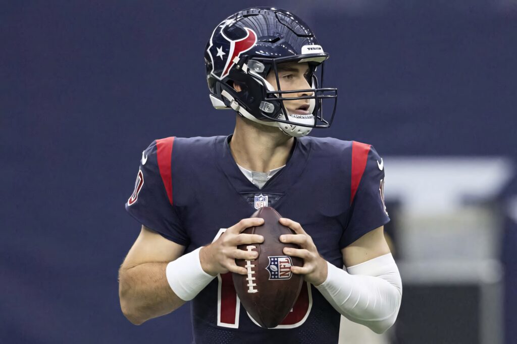 Davis Mills Houston Texans quarterback in full uniform grips football preparing NFL game play Wallpaper