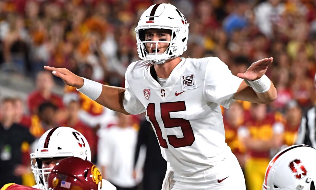 Davis Mills in white Stanford uniform leads offense at line of scrimmage under stadium lights Wallpaper
