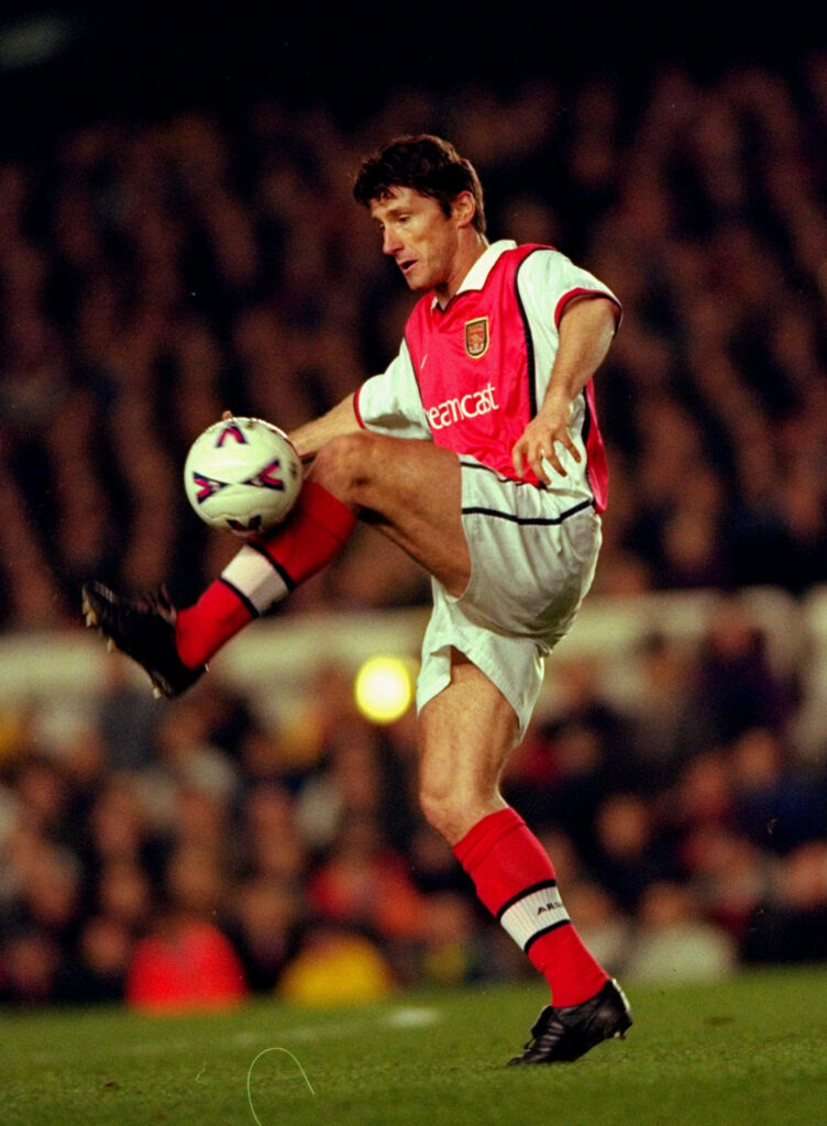 Davor Šuker airborne controlling ball in red white Arsenal kit during football match action Wallpaper