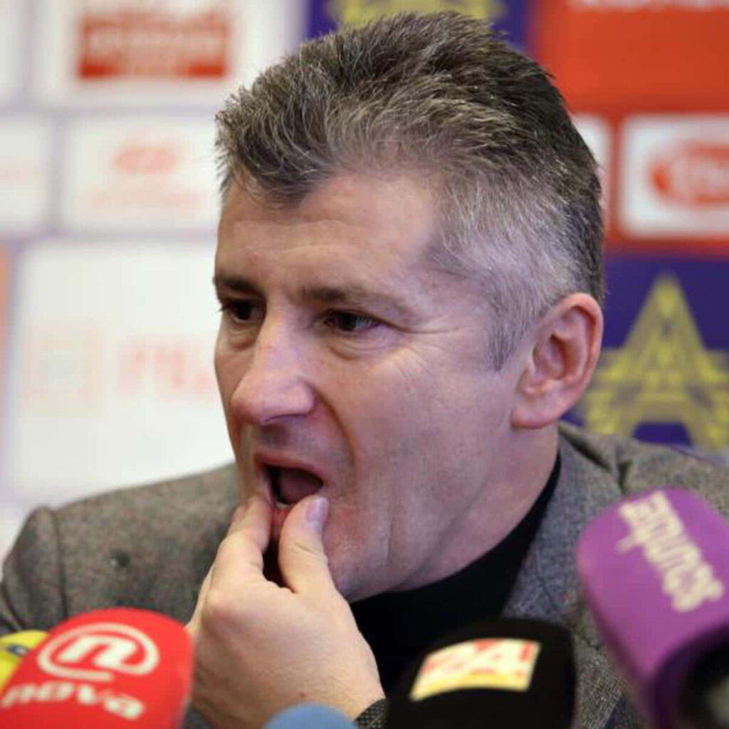 Davor Šuker at football press conference with microphones vibrant professional wallpaper background