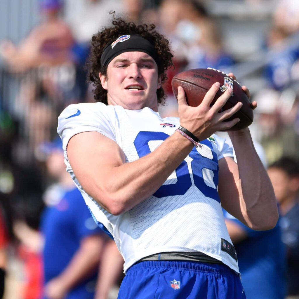 Dawson Knox catching football pass in white Buffalo Bills jersey during energetic practice session Wallpaper