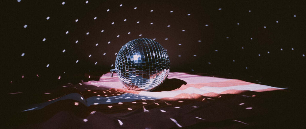 Dazzling disco ball casting geometric light patterns in a retro minimalist pink silver brown room Wallpaper