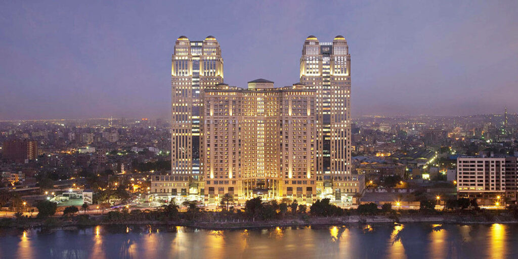 Experiencing Majestic Nile Views: The Lavish Fairmont Nile City Hotel at Dusk - Cairo's Captivating Riverside Oasis Wallpaper