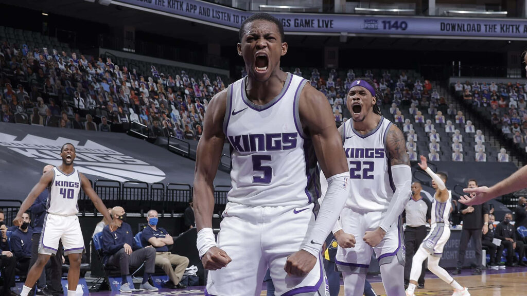 DeAaron Fox celebrates passionately on court in Sacramento Kings purple and white uniform Wallpaper