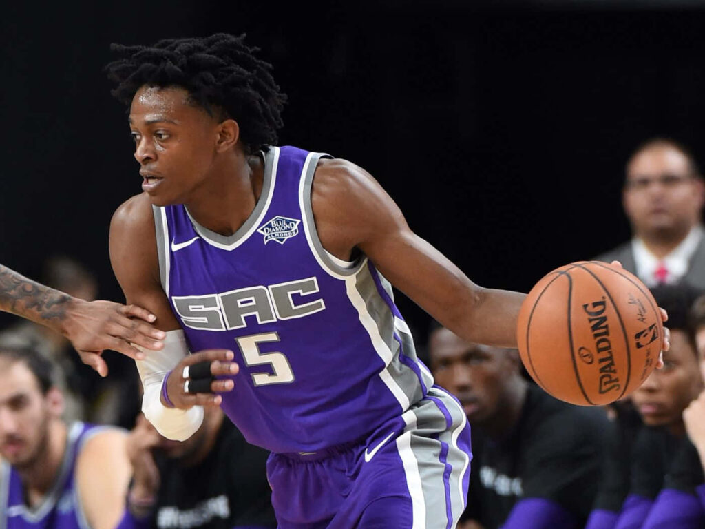 DeAaron Fox Sacramento Kings dribbling basketball in purple jersey high energy NBA action wallpaper