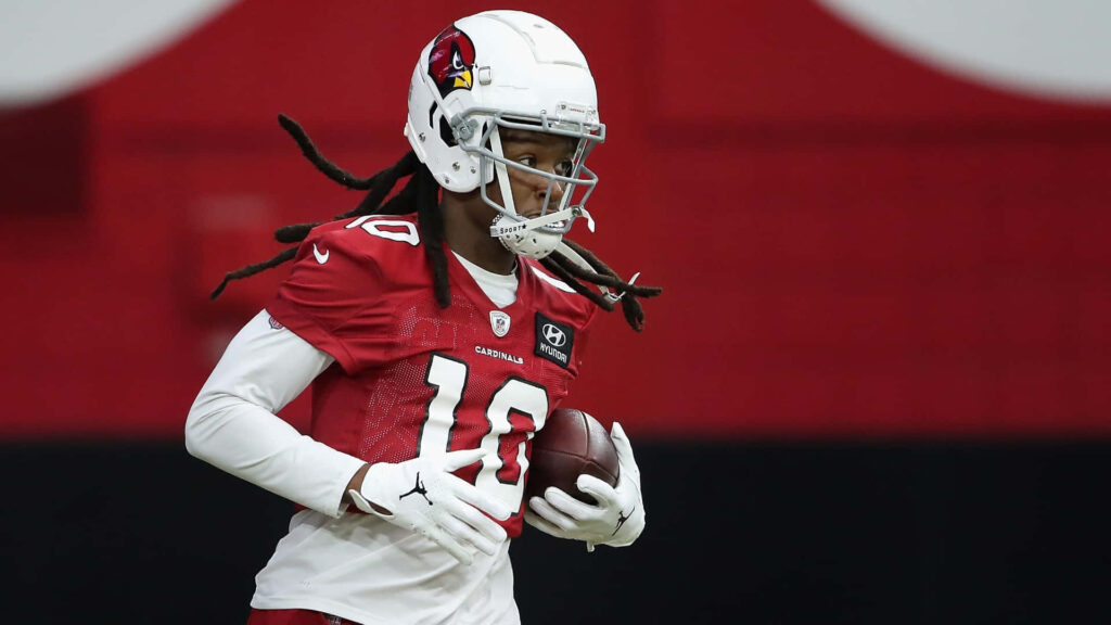 DeAndre Hopkins Arizona Cardinals practice action red white uniform focused holding football indoors Wallpaper