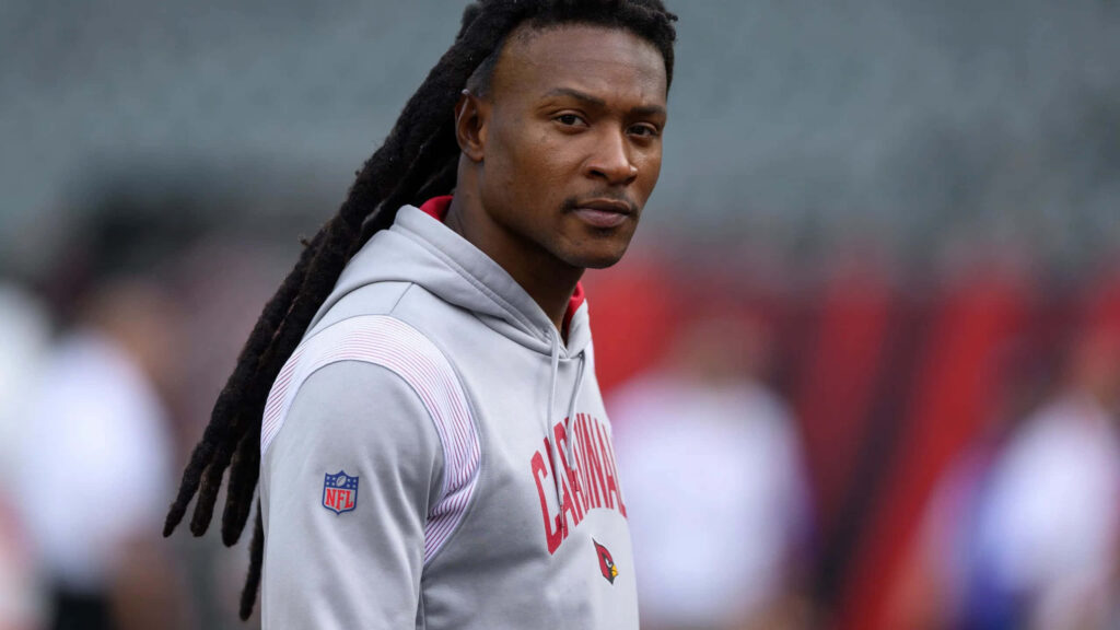 DeAndre Hopkins in Arizona Cardinals hoodie focused during NFL pregame warmup with stadium backdrop Wallpaper