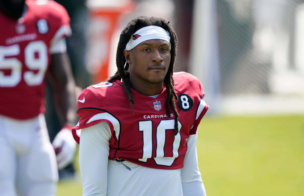 DeAndre Hopkins in red Arizona Cardinals jersey number 10 training on sunny football practice field Wallpaper