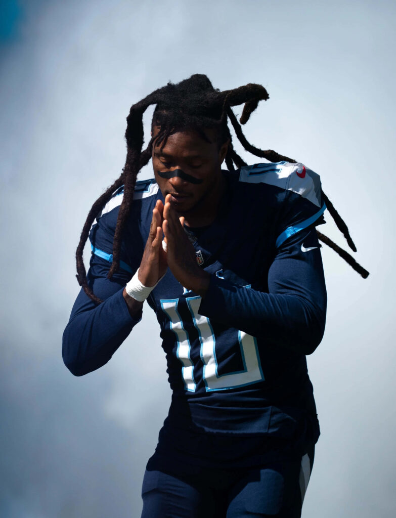 DeAndre Hopkins in Tennessee Titans uniform with intense focus against misty blue background Wallpaper