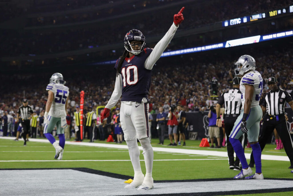 DeAndre Hopkins celebrates touchdown in Houston Texans uniform under bright stadium lights Wallpaper