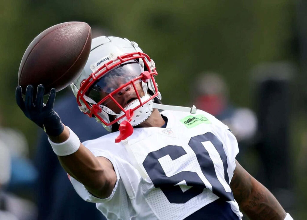 DeMario Douglas catching football in Patriots gear showing focus and athleticism during practice Wallpaper