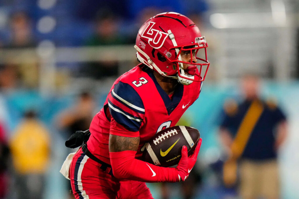 Liberty University Football player DeMario Douglas in red uniform running with ball in stadium Wallpaper