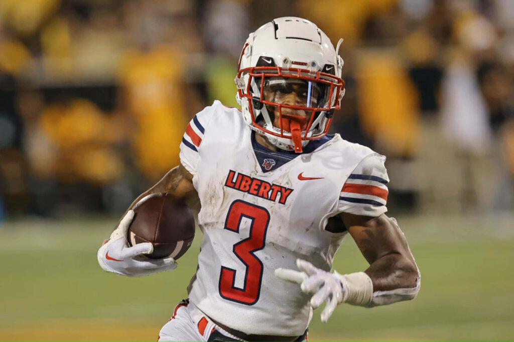 Liberty University Football DeMario Douglas intense action shot in white red uniform stadium background Wallpaper