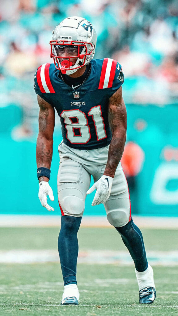DeMario Douglas in New England Patriots uniform focused on football field intense game day energy Wallpaper