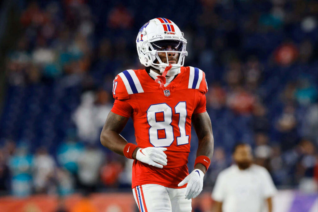 DeMario Douglas number 81 in red blue white jersey walking confidently on football field wallpaper