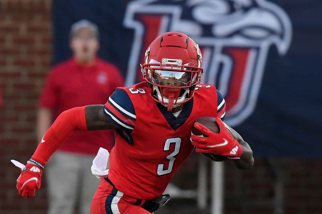 DeMario Douglas sprinting in red football uniform fast action intense game moment wallpaper